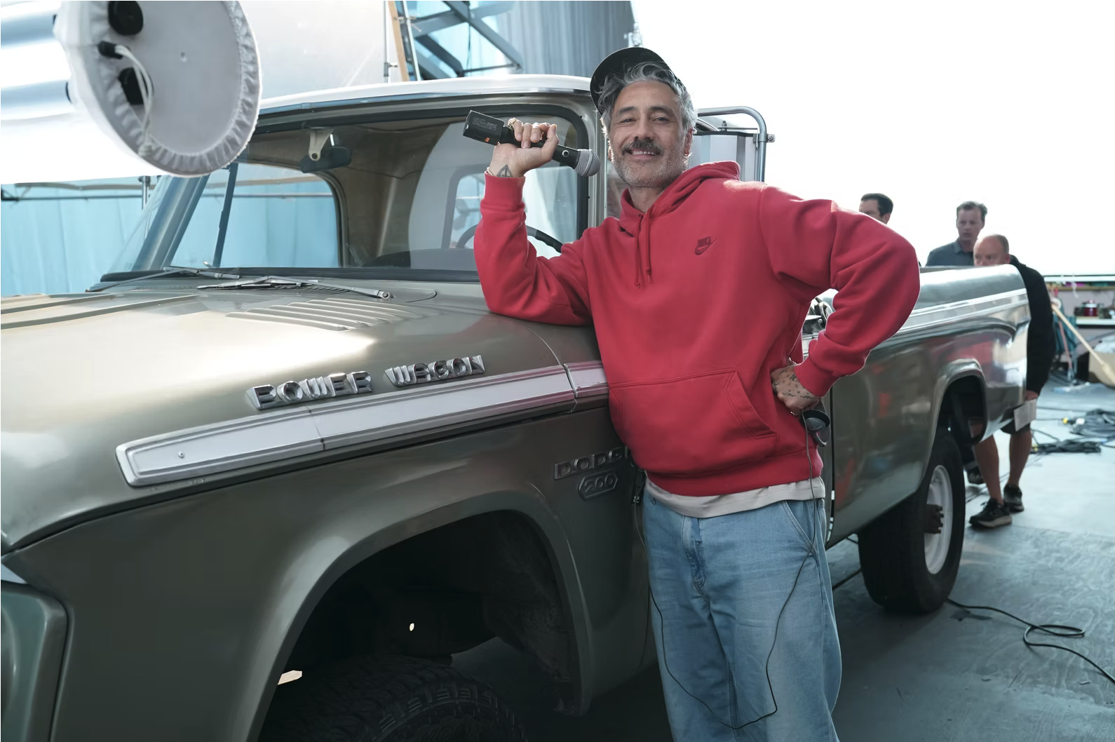 Taika Waititi standing beside a vintage Dodge Power Wagon on set