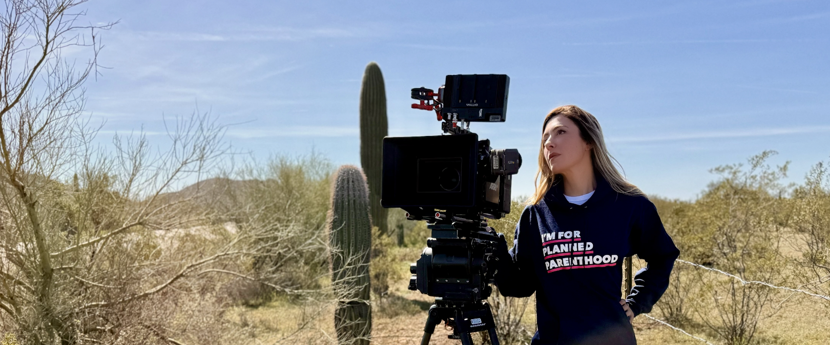 Lara Everly directing beside a camera in the desert