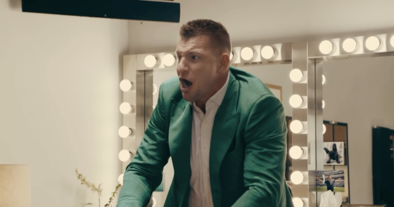 Rob Gronkowski in a green jacket in a dressing room
