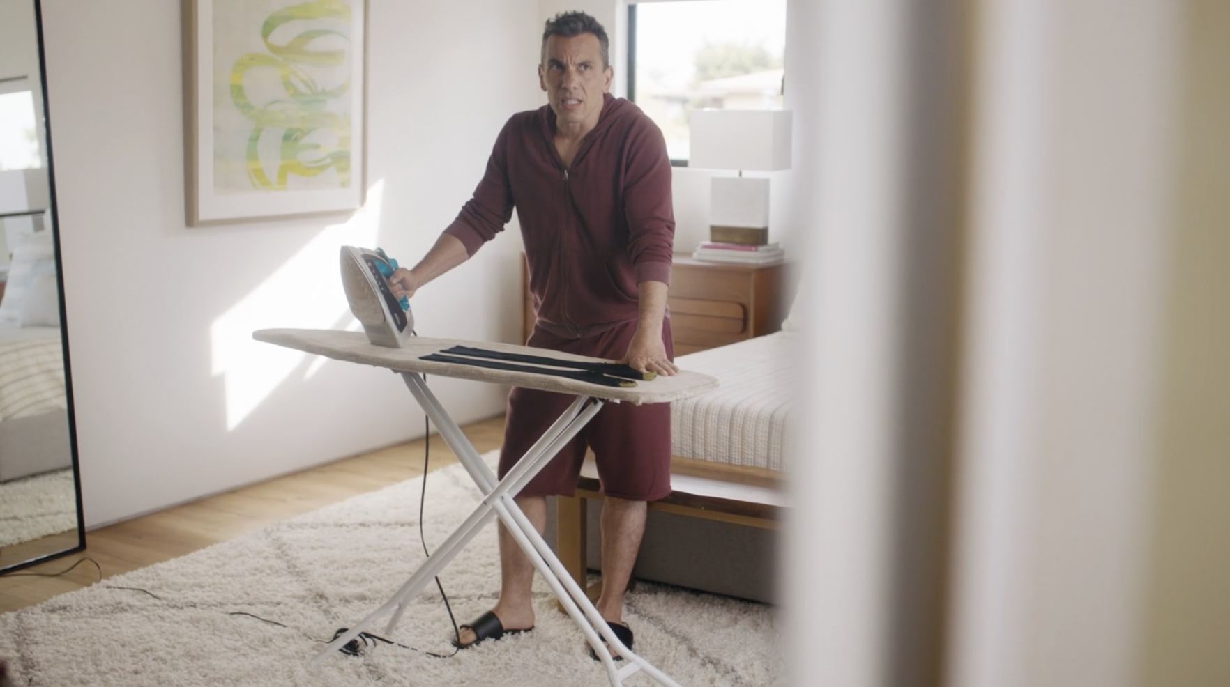 Sebastian Maniscalco ironing in a bedroom